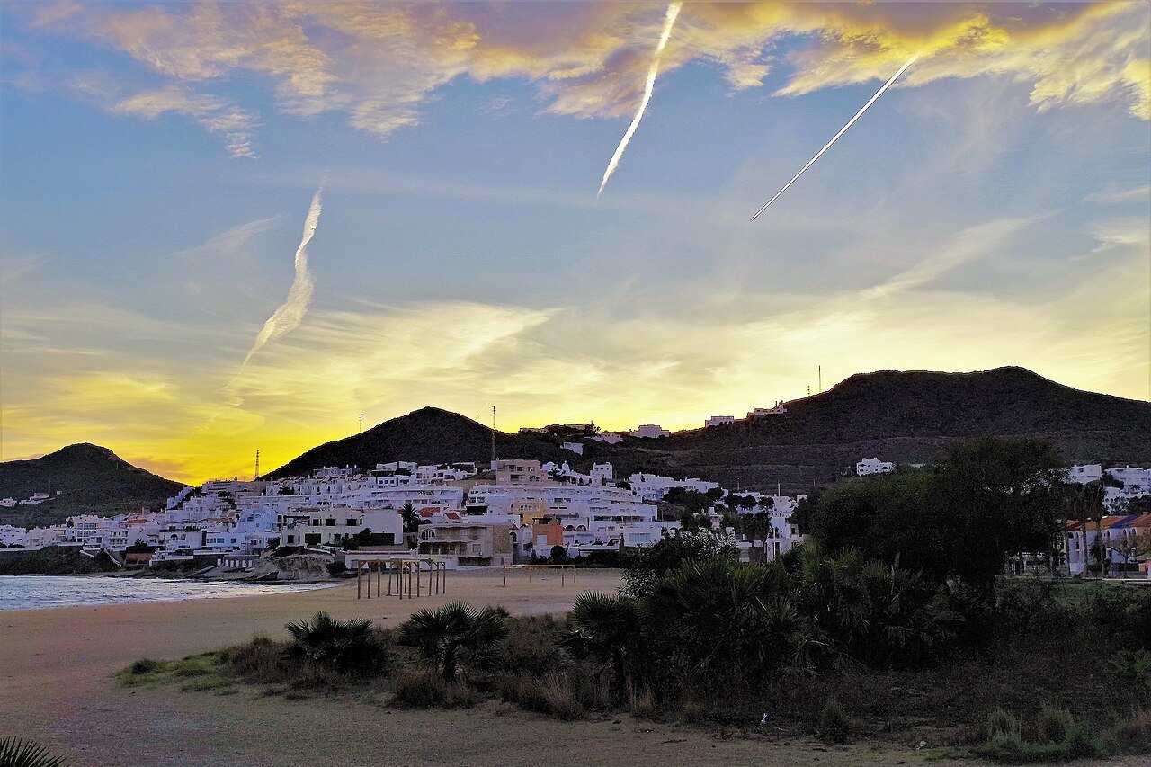 San José al atardecer: el pueblo blanco junto a la playa, con los cerros detrás